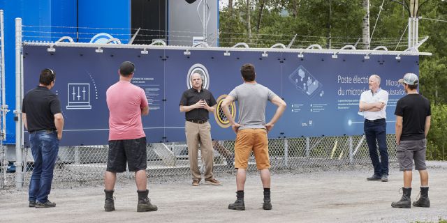 Visiteurs devant les batteries de stockage EVLO.